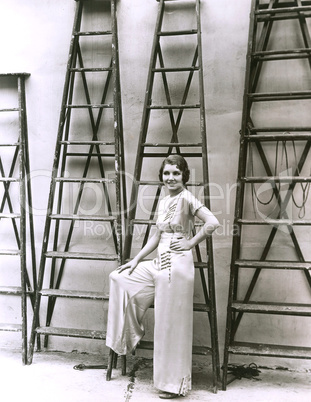 Young woman posing in front of ladders