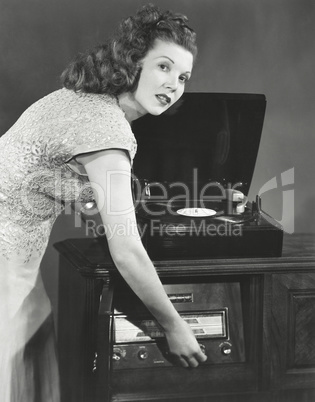 Woman playing record album on phonograph