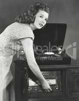 Woman playing record album on phonograph