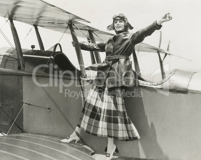 Aviatrix standing on bi-plane