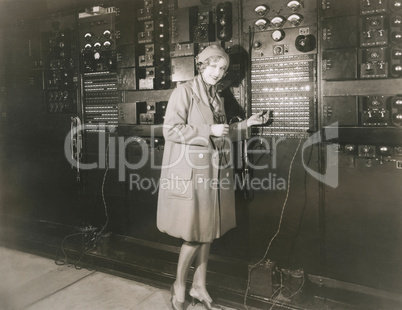 Woman monitoring sound in 1930s recording studio