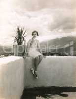 Woman sitting on outdoor ledge