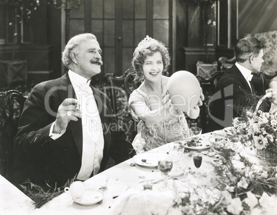 Woman holding balloon at dinner party