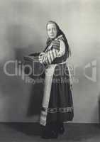 Woman in peasant dress carrying basket