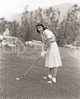 Woman in white gloves playing golf