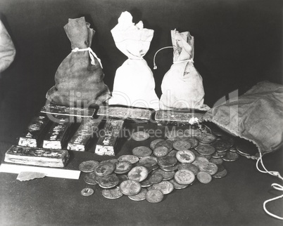 Gold coins and bars laid out on table