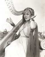 Woman in ancient Greek costume playing harp