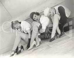 Three woman sitting on floor of ship