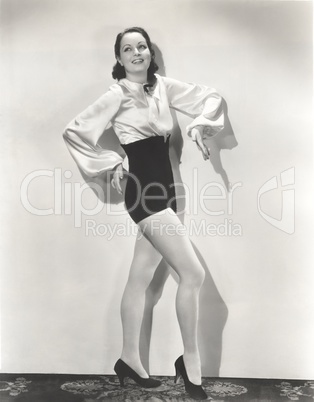 Dancer posing in high-waisted shorts and silk blouse