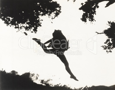 Silhouette of woman leaping in mid-air