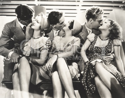 Three couples kissing