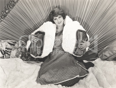 Woman sitting in bed with pillows