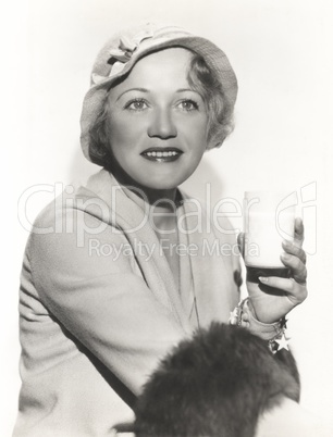 Woman in hat holding a glass of milk Woman in hat holding a glass of milk