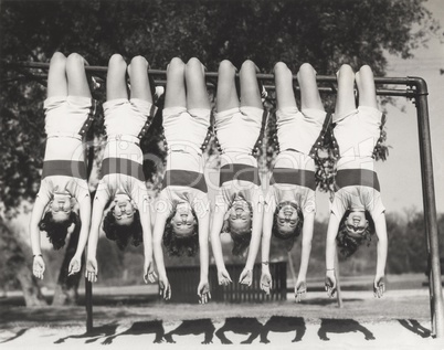 Showgirls hanging from monkey bars