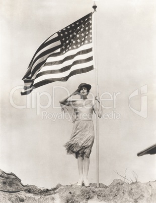 Patriotic woman holding American flag and saluting