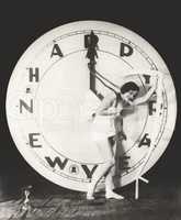 Woman pulling the hour hand of giant clock on New Year's Eve