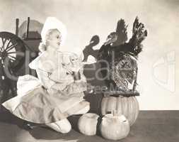 Woman holding doll wearing identical Thanksgiving costume
