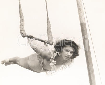 Female trapeze artist in mid-air