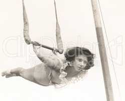 Female trapeze artist in mid-air