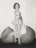 Woman standing by giant cracked egg shell