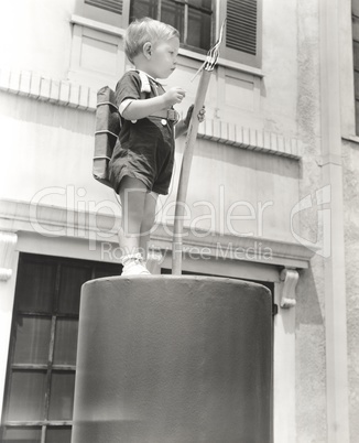 Little boy standing on giant firecracker prop