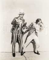 Two people in 18th century costumes playing with firecrackers