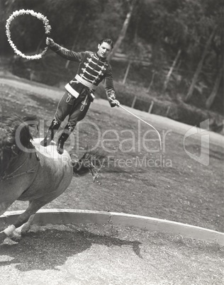 Man performing stunt while standing on horse