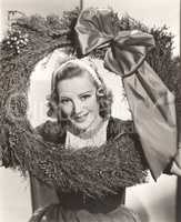 Woman holding large Christmas wreath with bow