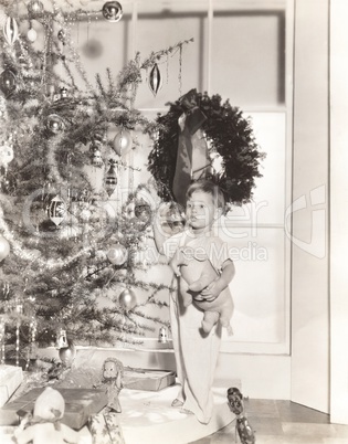 Little boy standing by tree on Christmas morning