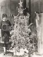 Woman standing by decorated Christmas tree