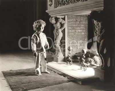 Smiling boy in front of fireplace holding Christmas stocking