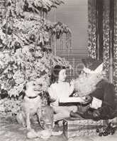 Santa Claus giving gift to little girl and her dog