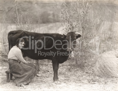 Woman sitting by cow