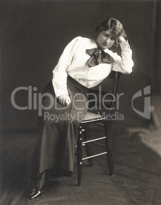 Pensive woman sitting on chair