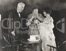 Three people enjoying a slice of cake