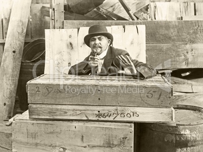 Cornered man behind wooden crates pointing gun