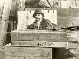 Cornered man behind wooden crates pointing gun