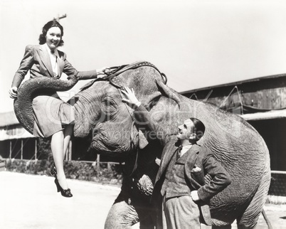 Young man looking at woman lifted by elephant