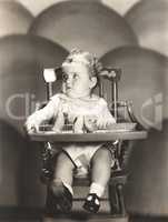 Cute baby sitting on high chair