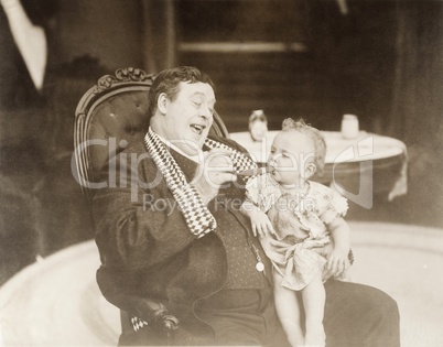 Man laughing at baby smoking cigar