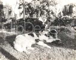 Woman sitting with her dog on grass