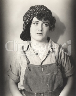 Woman in backwards cap and bib overalls