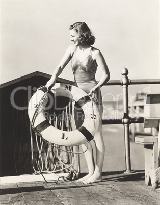 Woman on pier holding a life preserver