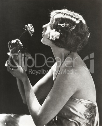 Profile view of young woman smelling flower