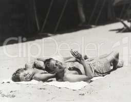 Happy couple sunbathing on beach