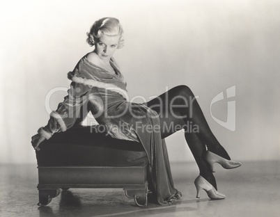 Woman in velvet dress sitting on footstool