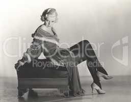 Woman in velvet dress sitting on footstool