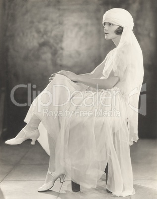 Woman in white chiffon dress and veiled turban
