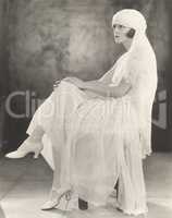 Woman in white chiffon dress and veiled turban