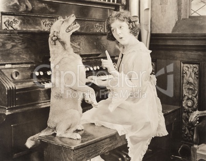 Dog accompanying woman on piano